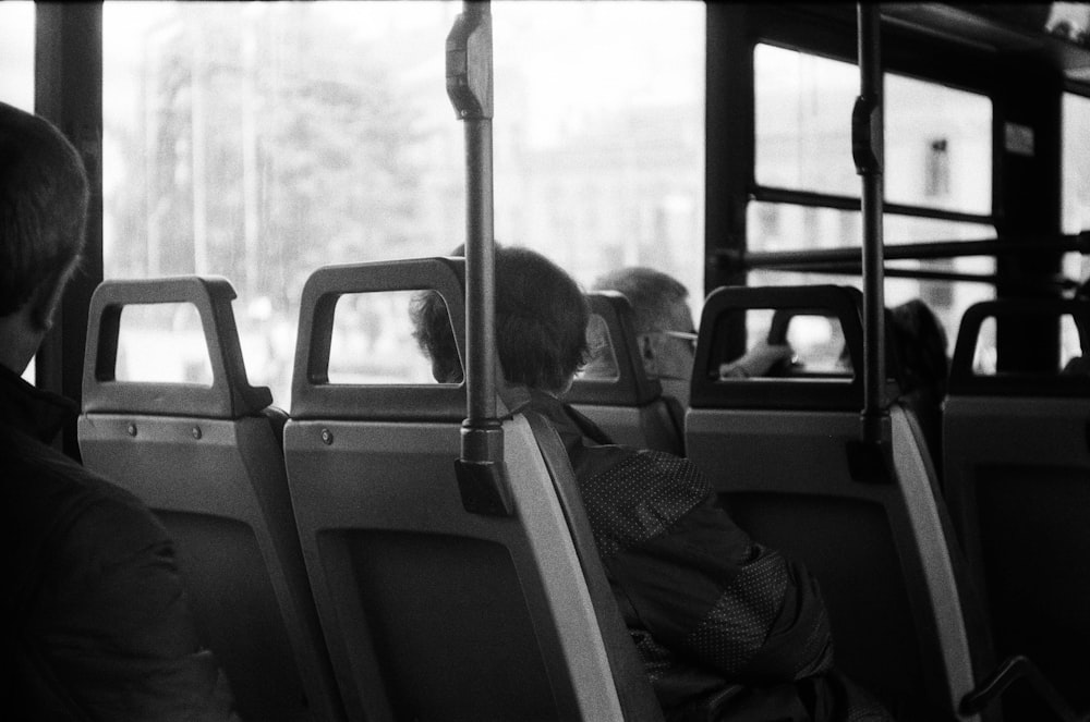 a black and white photo of a dog on a bus
