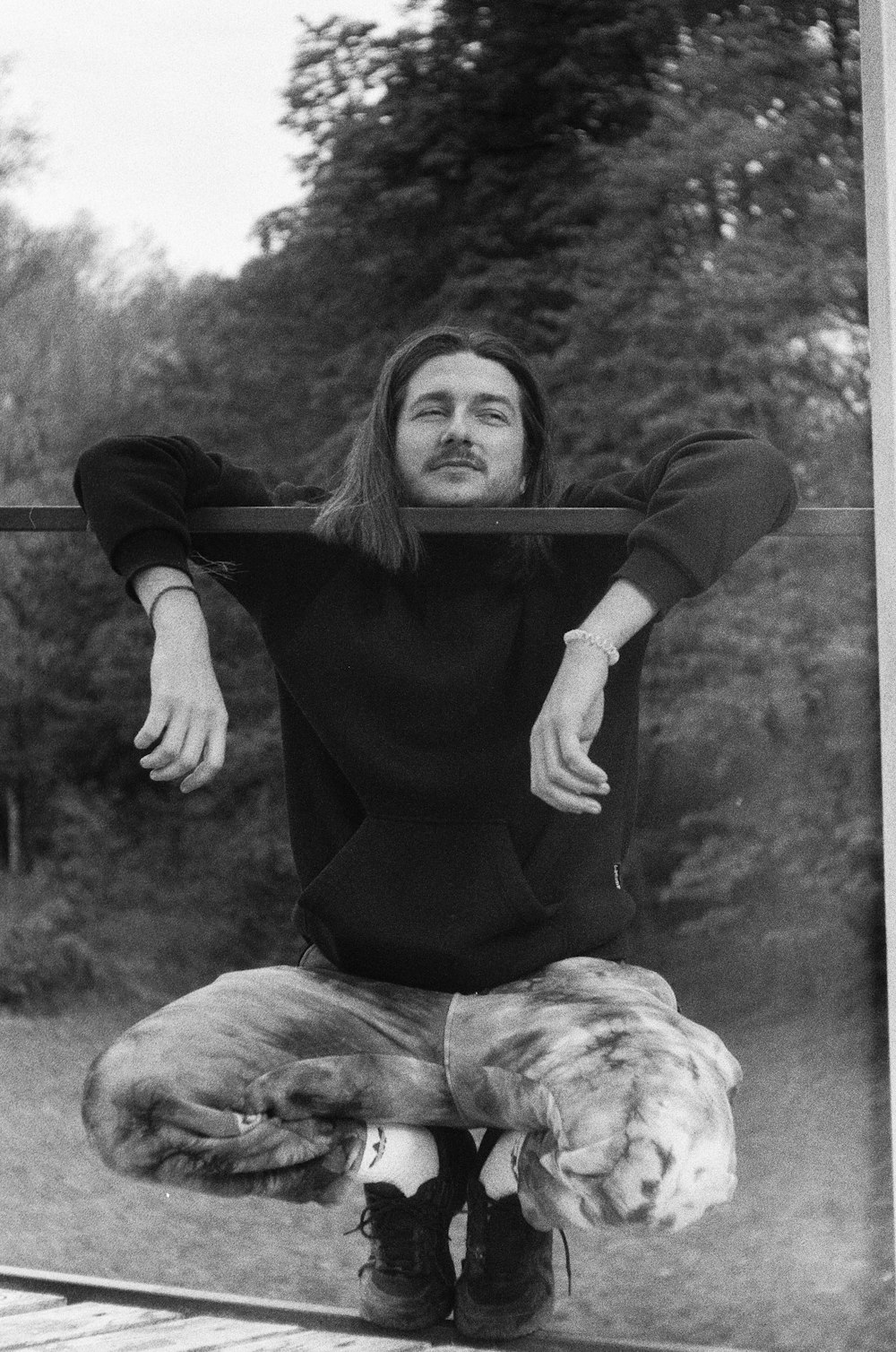 a man with long hair sitting on a bench