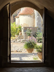 Sun-dappled courtyard of a traditional Grottole apartment with flowering pots.