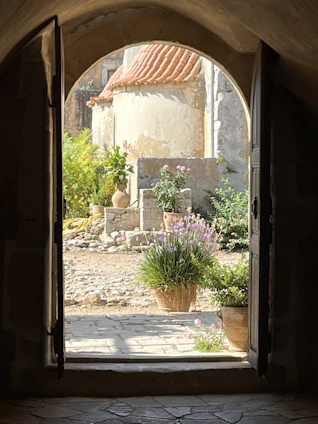 Sun-dappled courtyard of a traditional Grottole apartment with flowering pots.