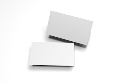 Two blank white business cards are placed against a white background. One card is slightly elevated and casts a shadow, creating a simple, minimalist composition.