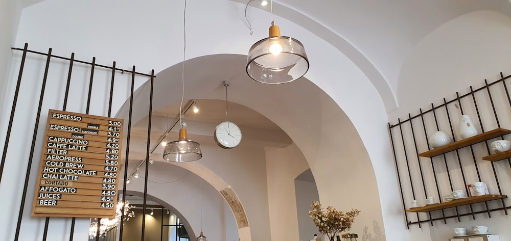 a clock is hanging from the ceiling of a restaurant