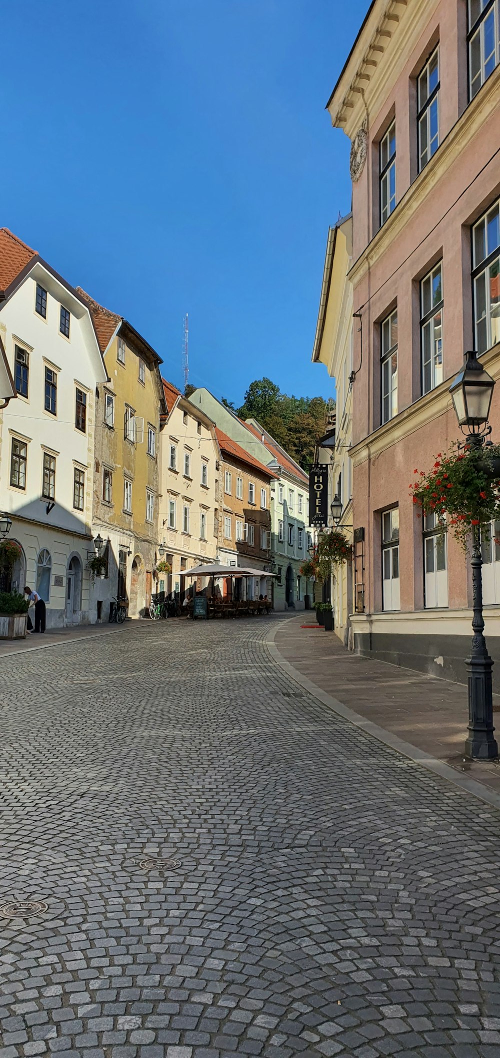 a cobblestone street with a clock tower in the background