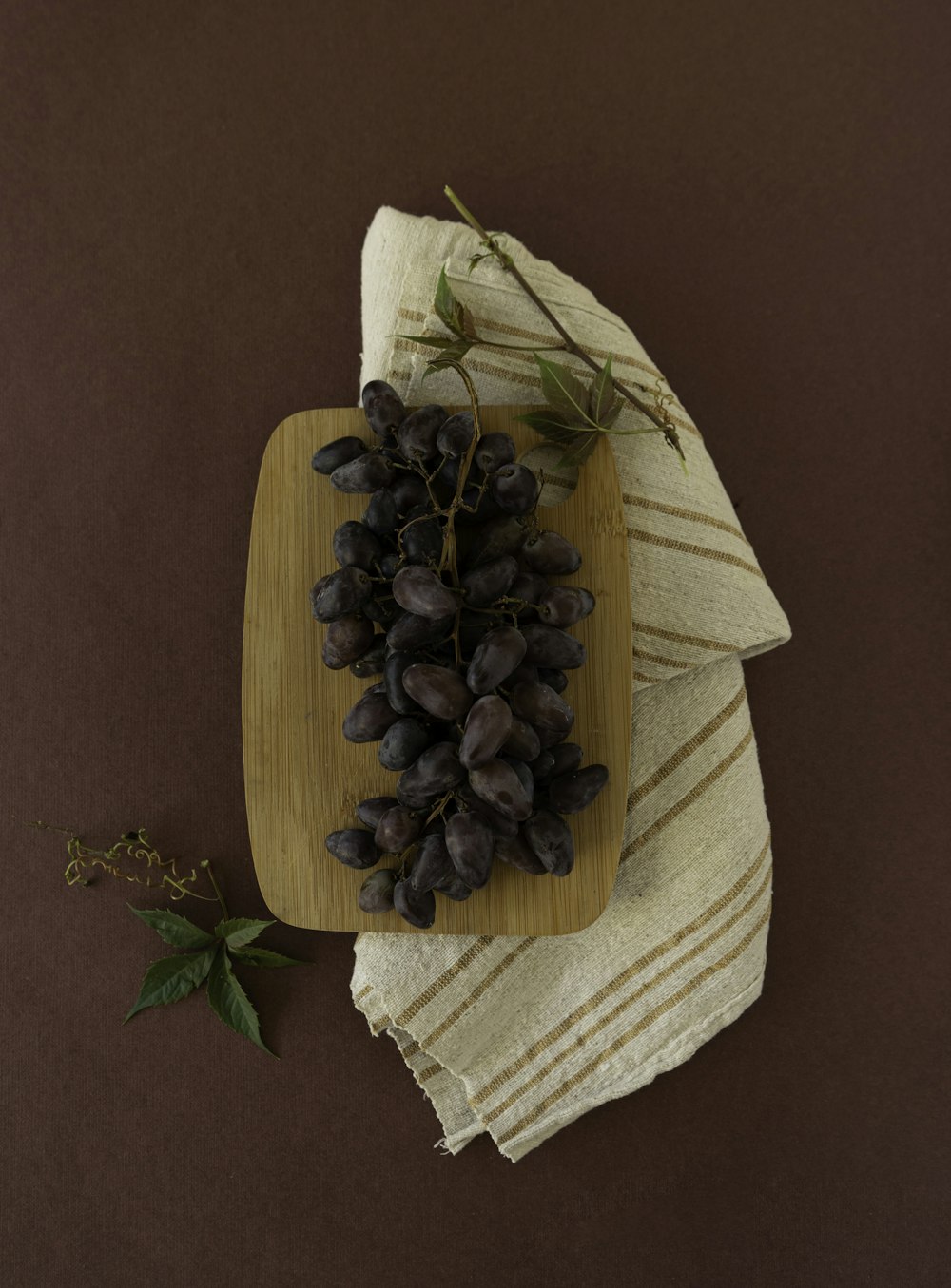 a bunch of grapes sitting on top of a wooden cutting board