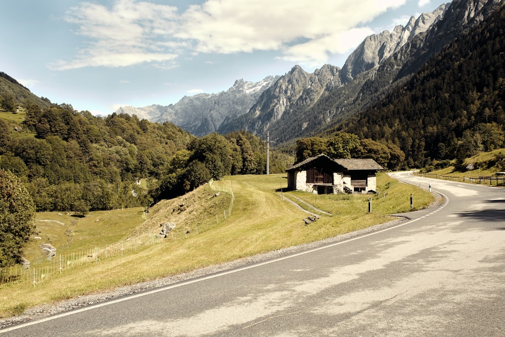 uma pequena casa ao lado de uma estrada de montanha