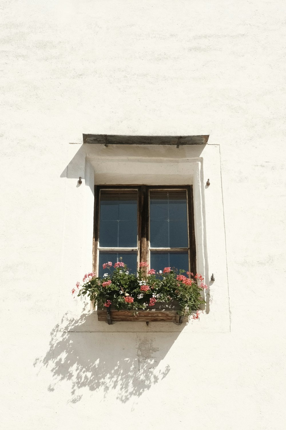 Ein weißes Gebäude mit Fenster und Blumenkasten