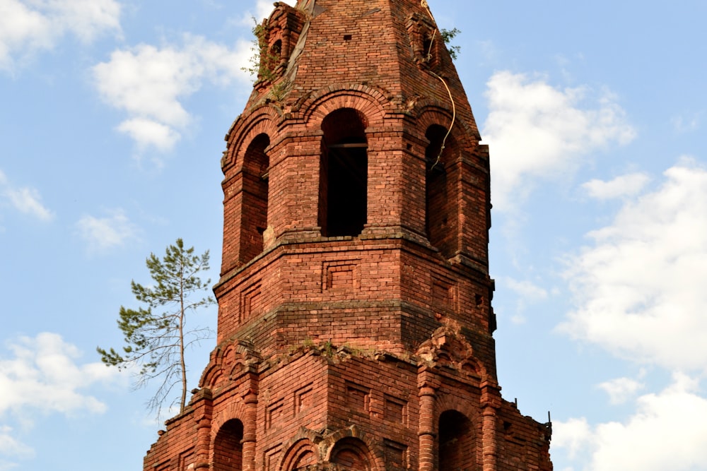 a tall brick clock tower with a clock on each of it's sides