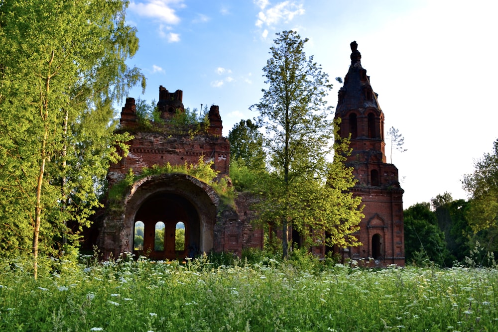 an old building with a clock tower in the middle of a field