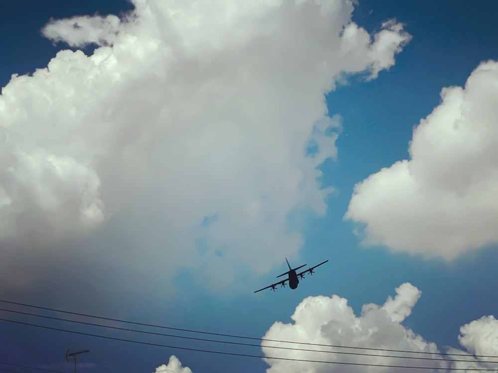 Un avión volando a través de un cielo azul nublado