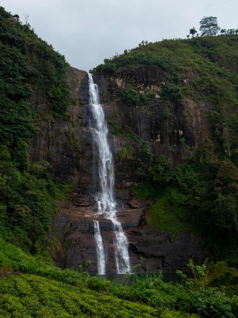 a large waterfall is in the middle of a mountain