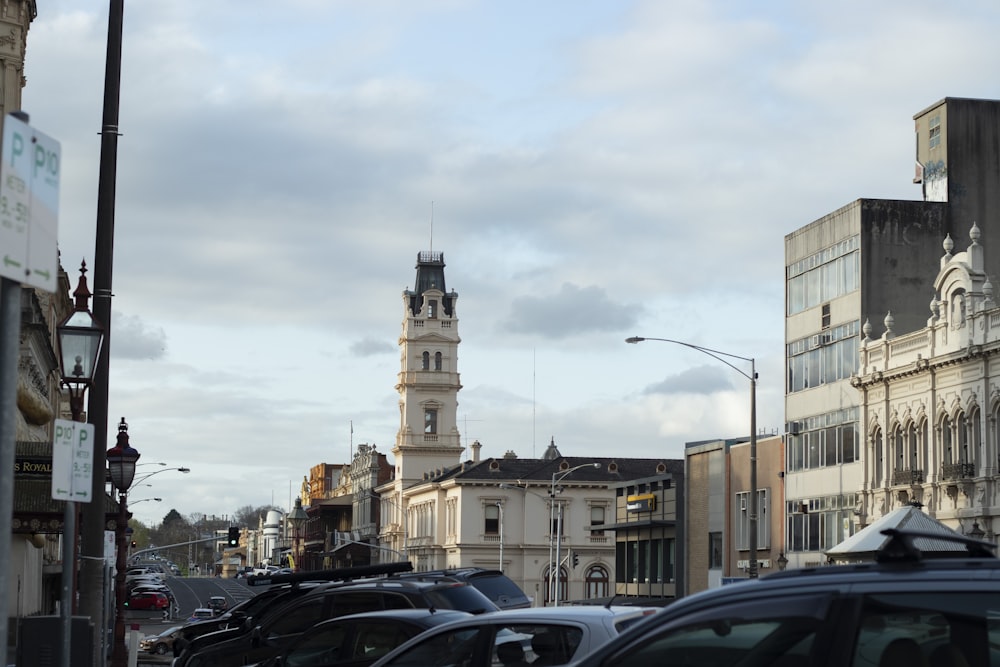 a busy city street with a clock tower in the background