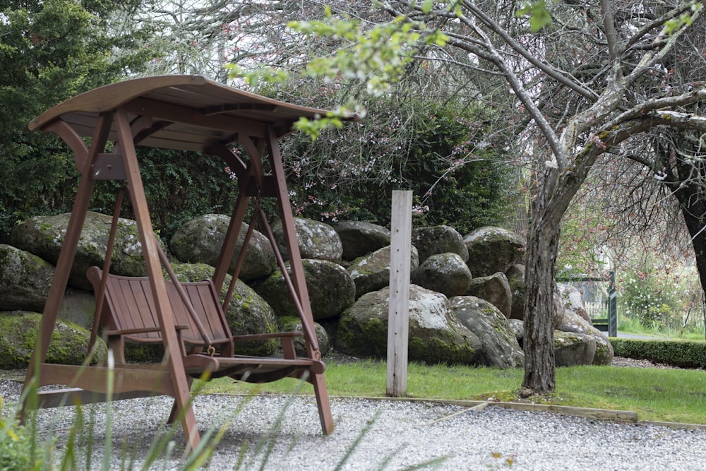 a wooden swing set in a park setting