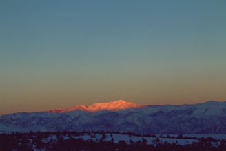 A wide-angle shot of a serene mountain range at sunrise with vibrant colors.