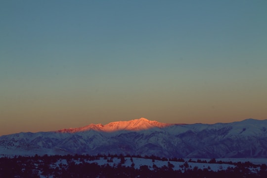 A wide-angle shot of a serene mountain range at sunrise with vibrant colors.