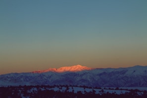 A serene landscape depicting a sunrise over a mountain range.