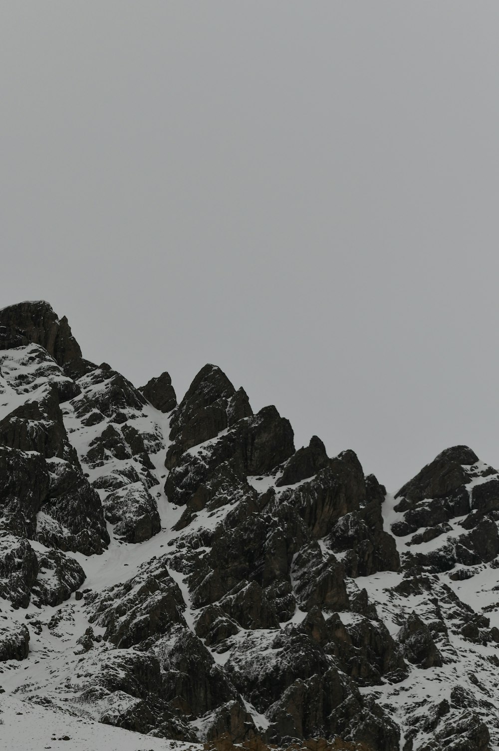 a mountain covered in snow with a sky background