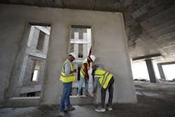 a group of men standing next to each other in front of a building