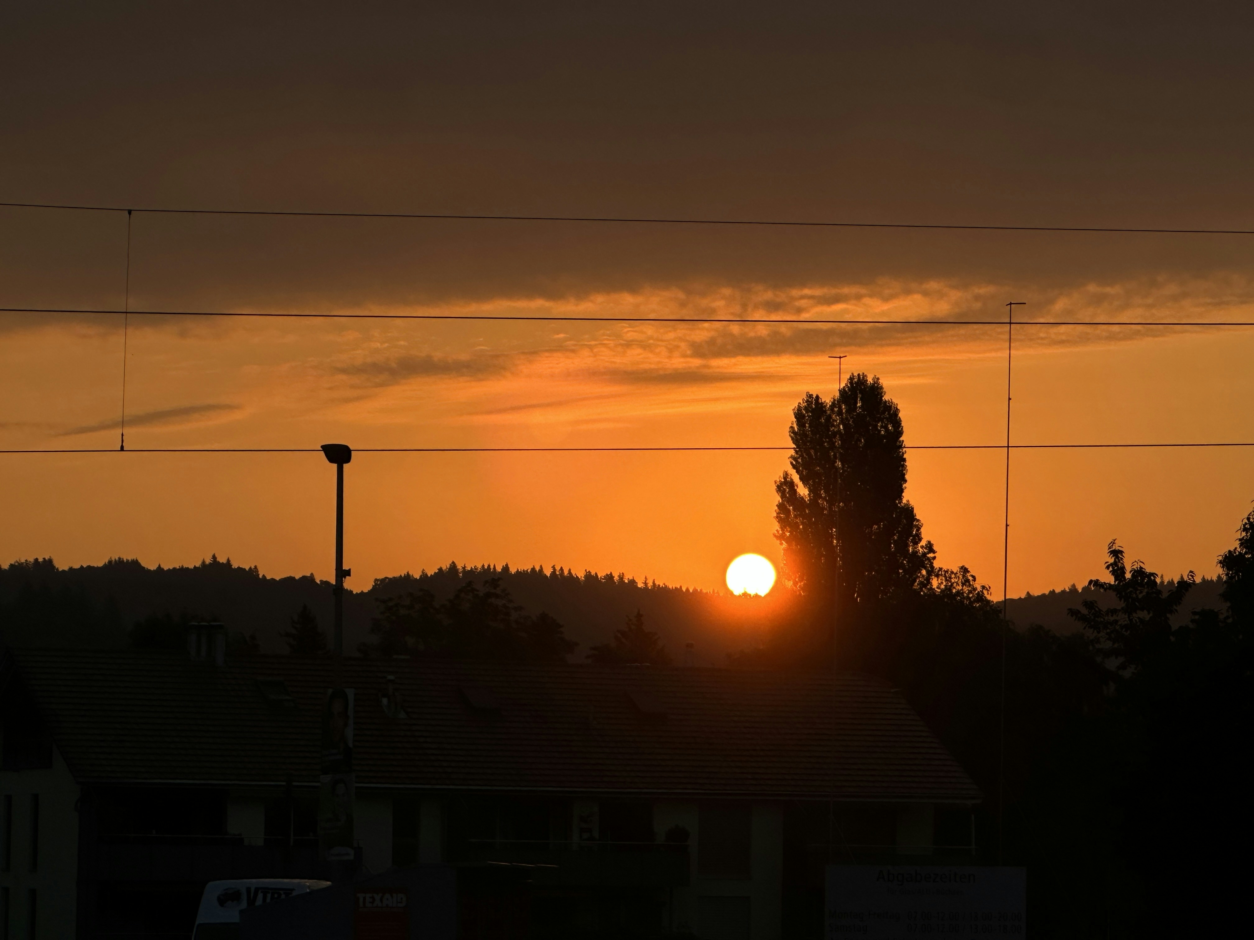 the sun is setting over a residential area