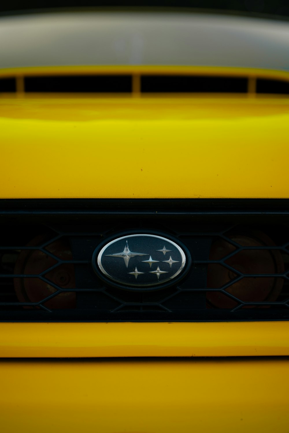 a close up of the emblem on a yellow sports car