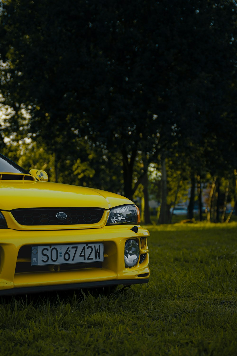 a yellow sports car parked in the grass