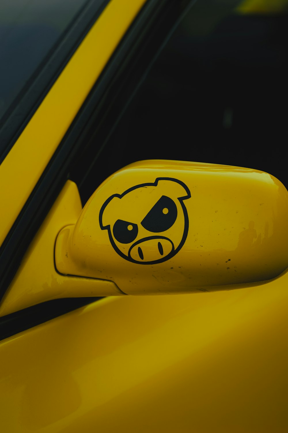 a close up of a yellow car with a smiley face on it