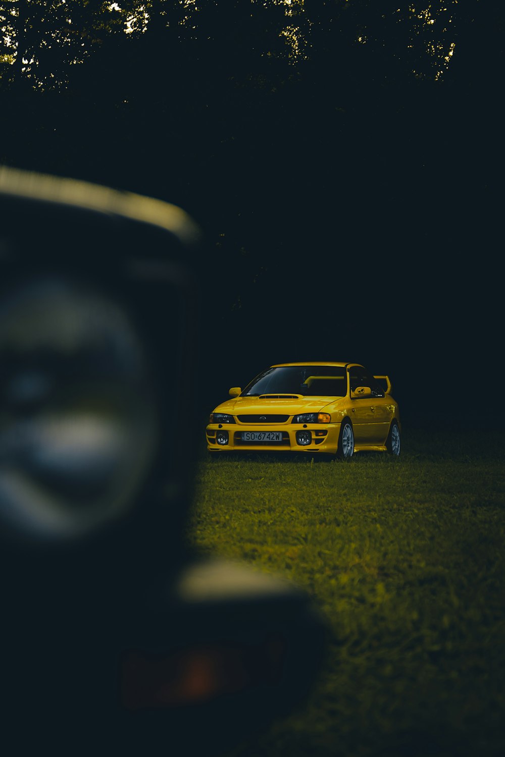 a yellow car is parked in the dark