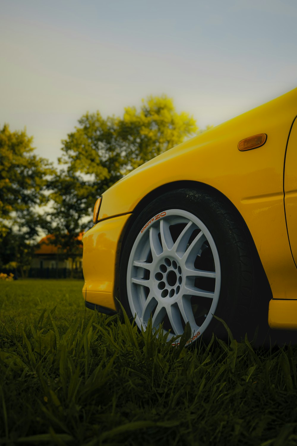 a yellow sports car parked in the grass