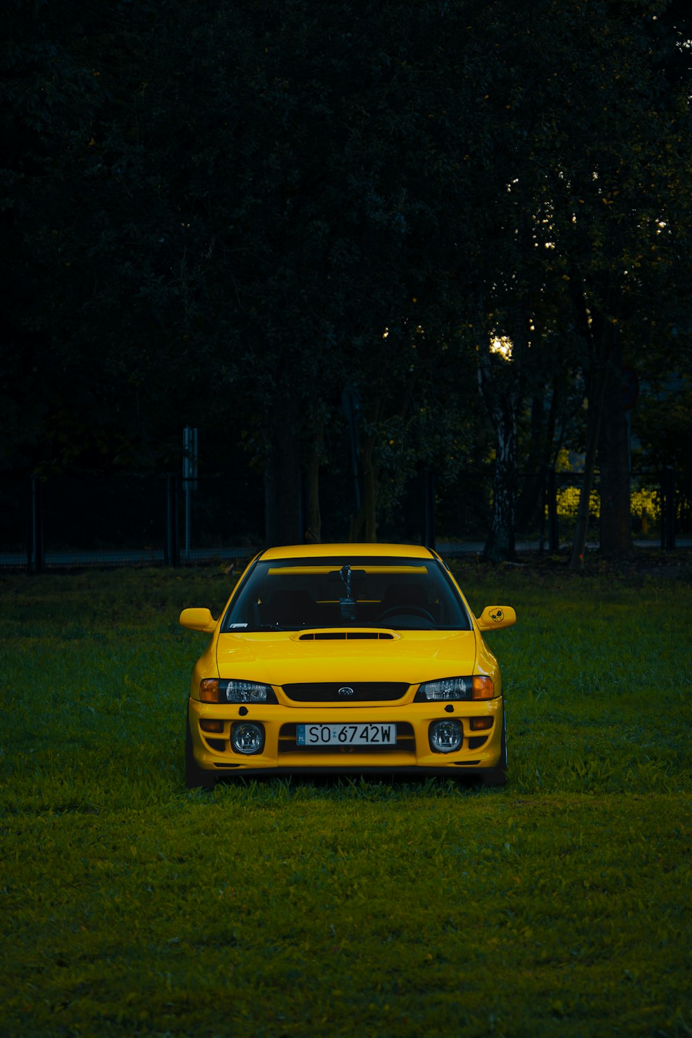 a yellow sports car parked in the grass