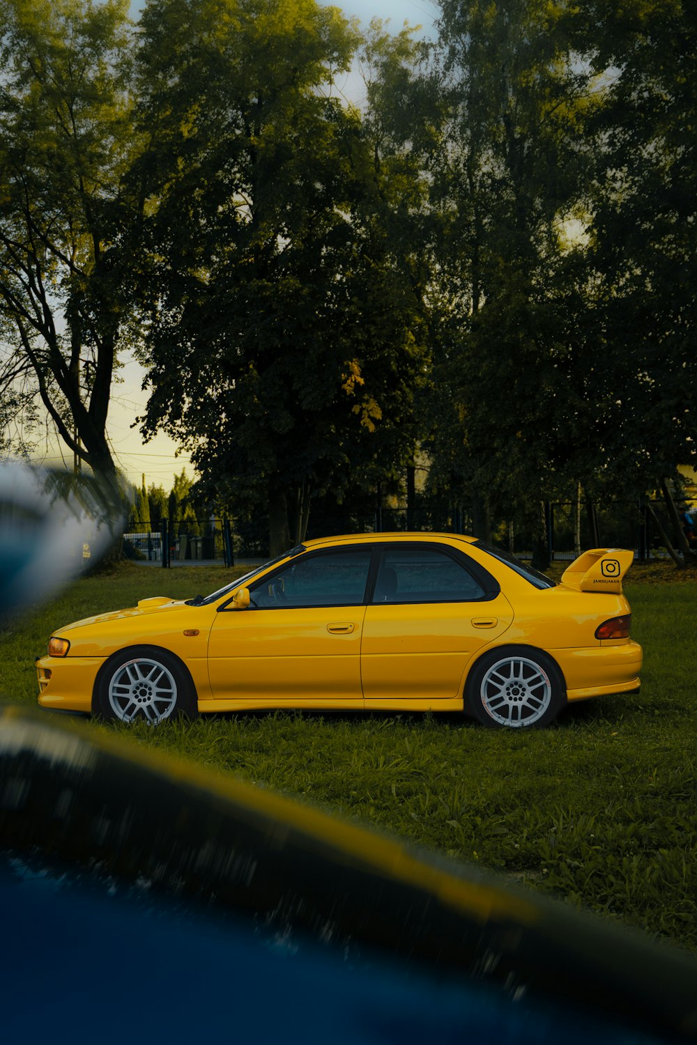 a yellow car is parked in the grass