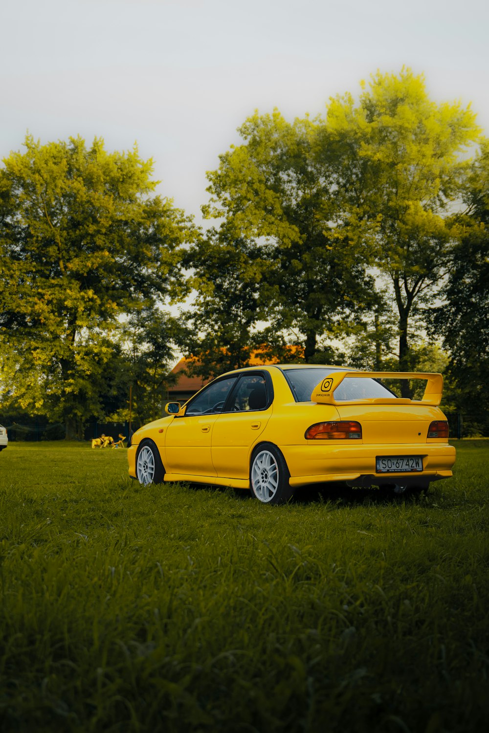 a yellow car parked in a grassy field