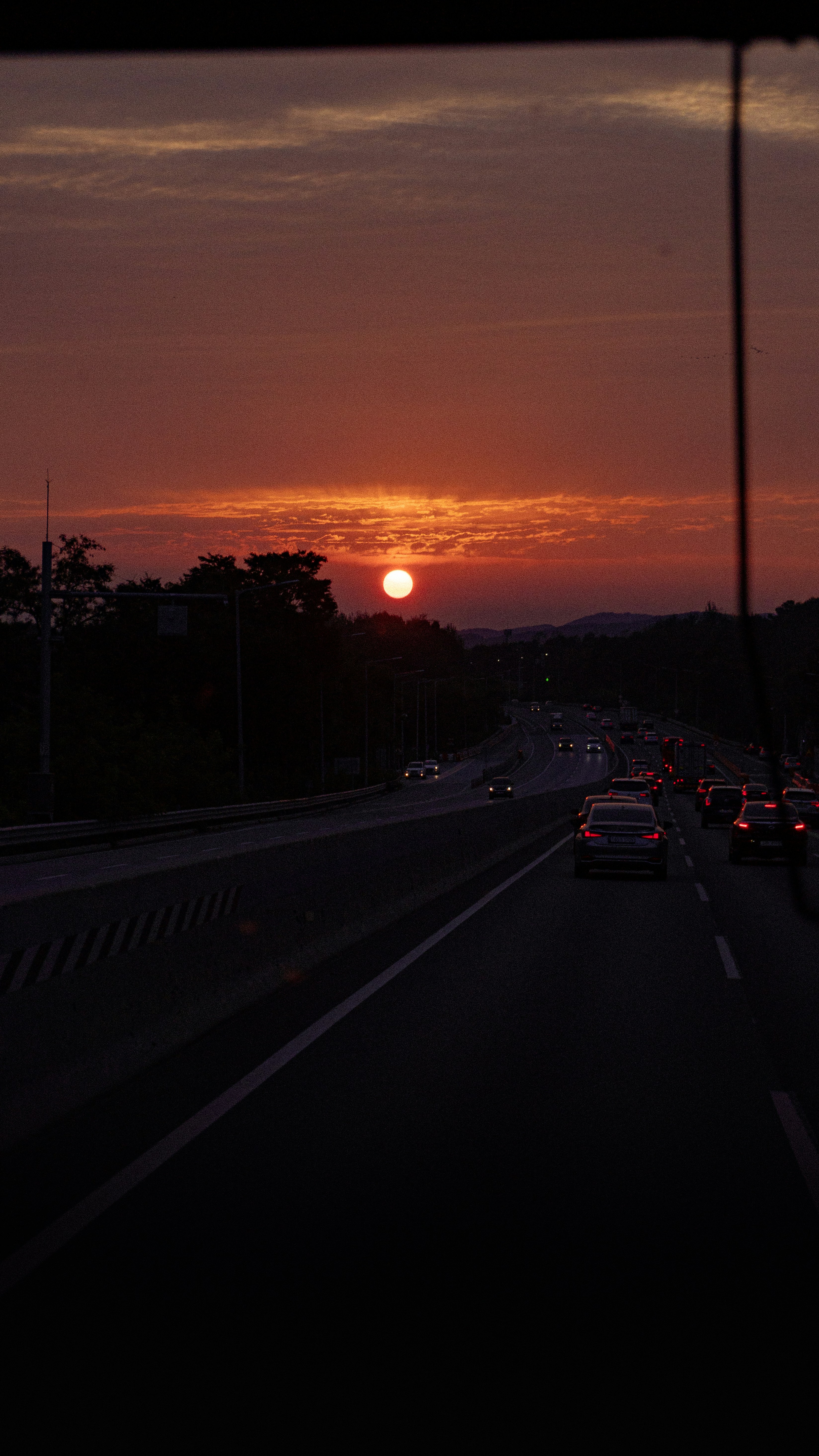 the sun is setting over a city street