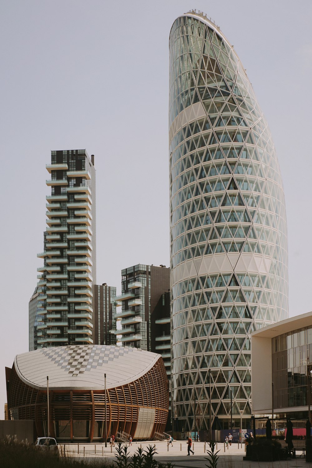 a tall building with a curved roof next to other tall buildings