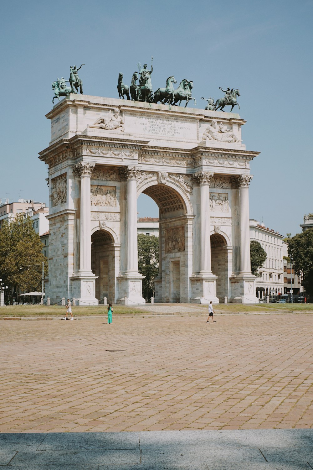 a large white arch with statues on top of it