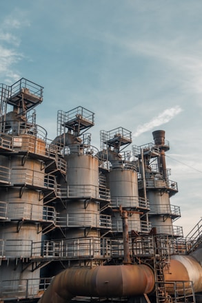 Industrial metal storage tanks being assembled in a modern factory setting.