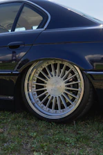 A fully detailed vehicle gleaming under natural sunlight on a driveway.