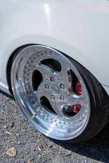 Close-up of a shiny car wheel and tire on a white vehicle