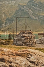 Guests enjoying an outdoor fire pit near the lake with mountains in the background.