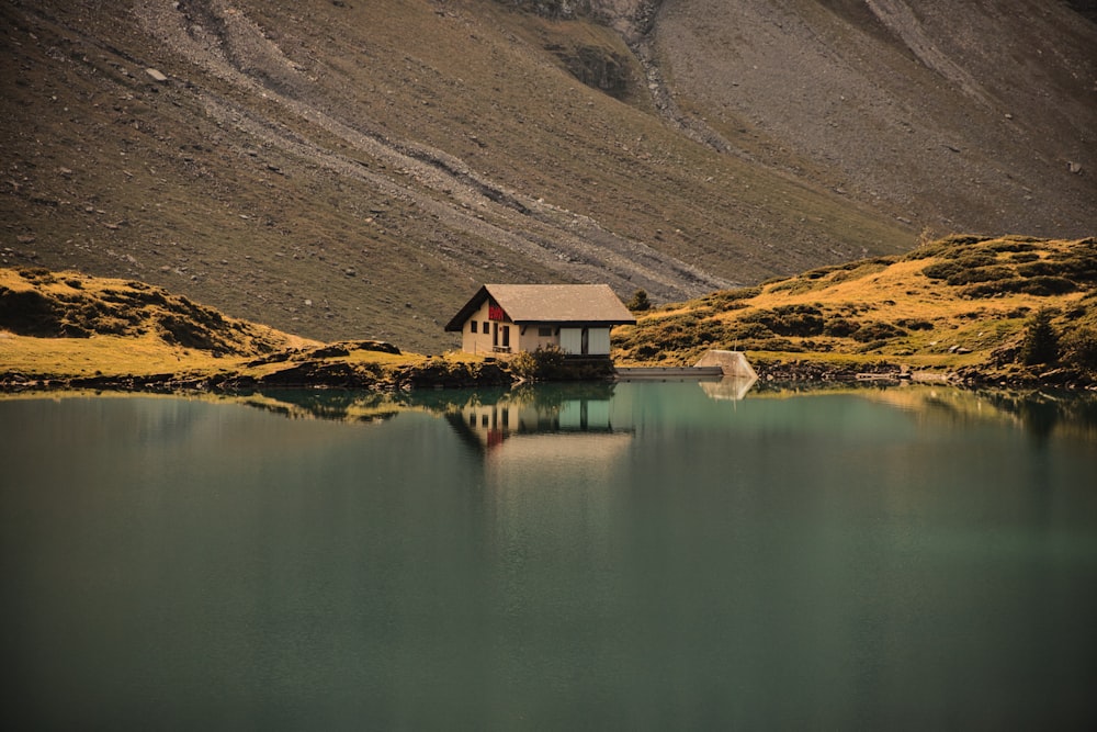 a small house sitting on the edge of a lake