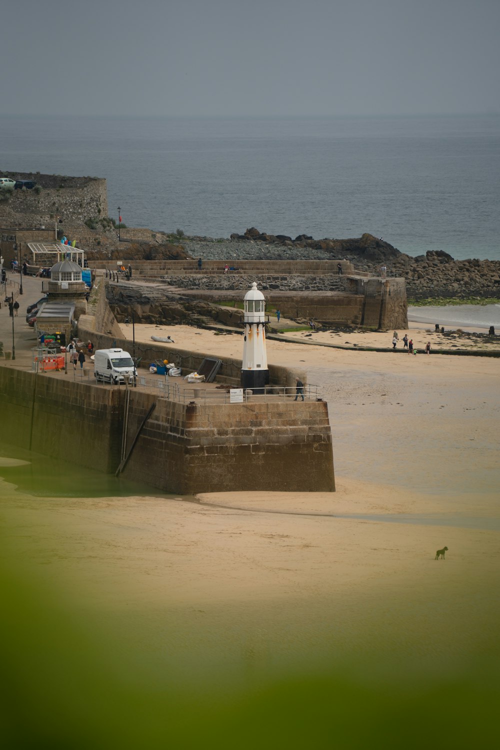 a beach with a light house in the middle of it