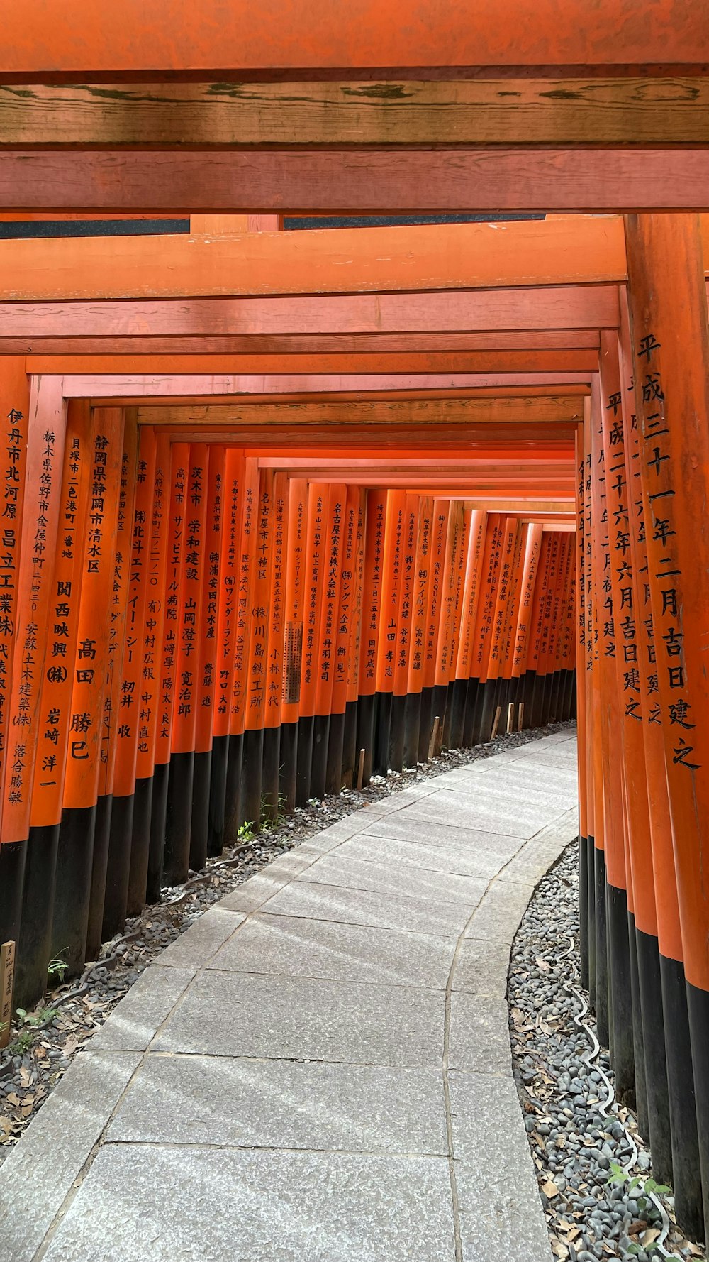 a walkway lined with orange and black columns