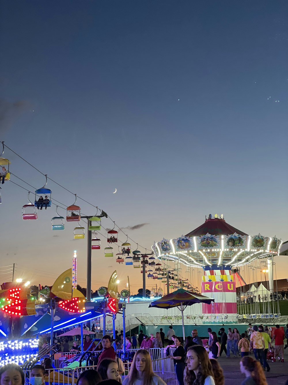 a group of people standing around a carnival ride