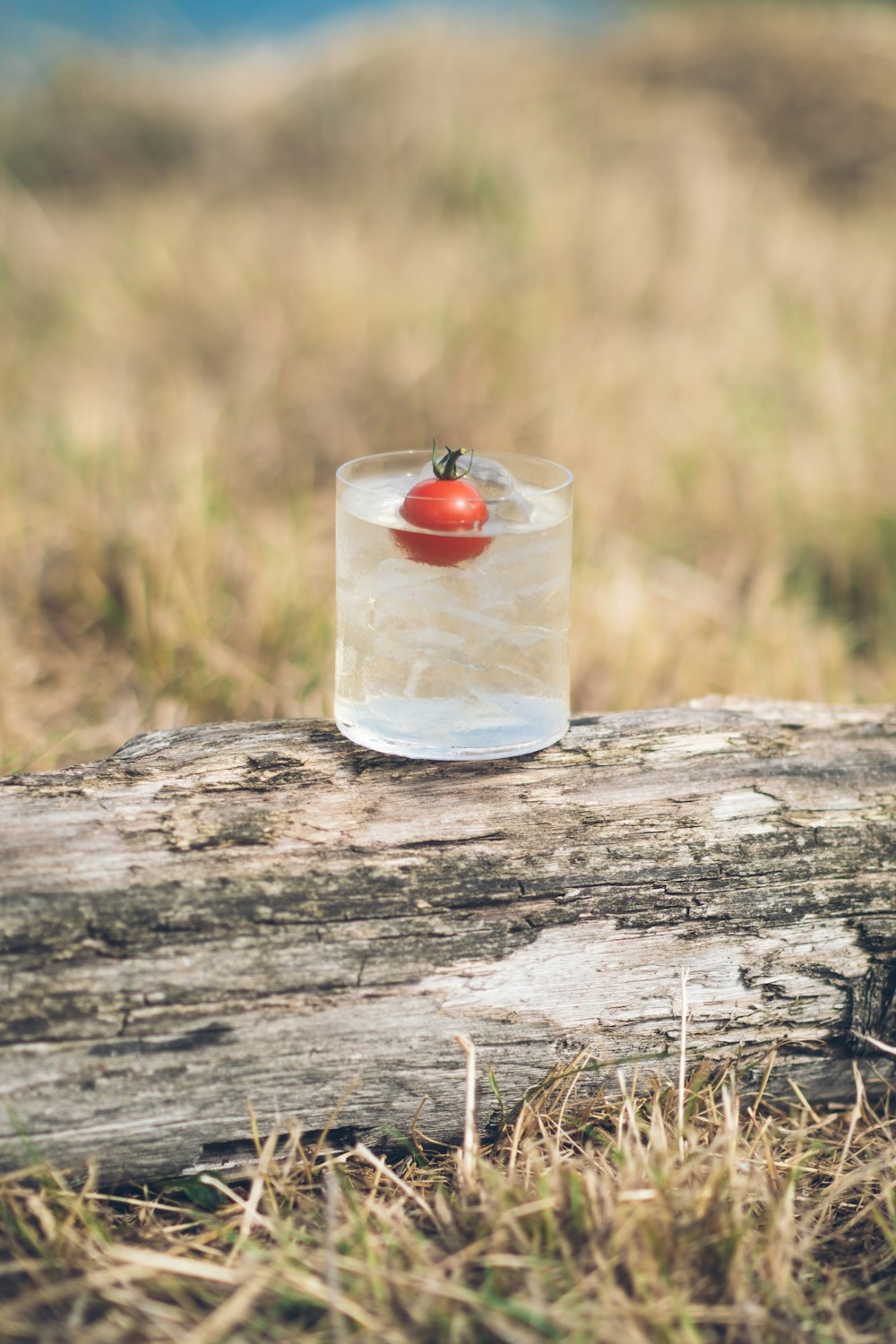 a glass of water with a cherry in it