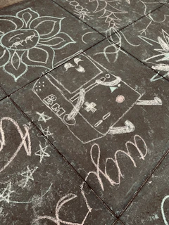 A colorful chalk drawing on a sidewalk encouraging kindness and skipping snacks.