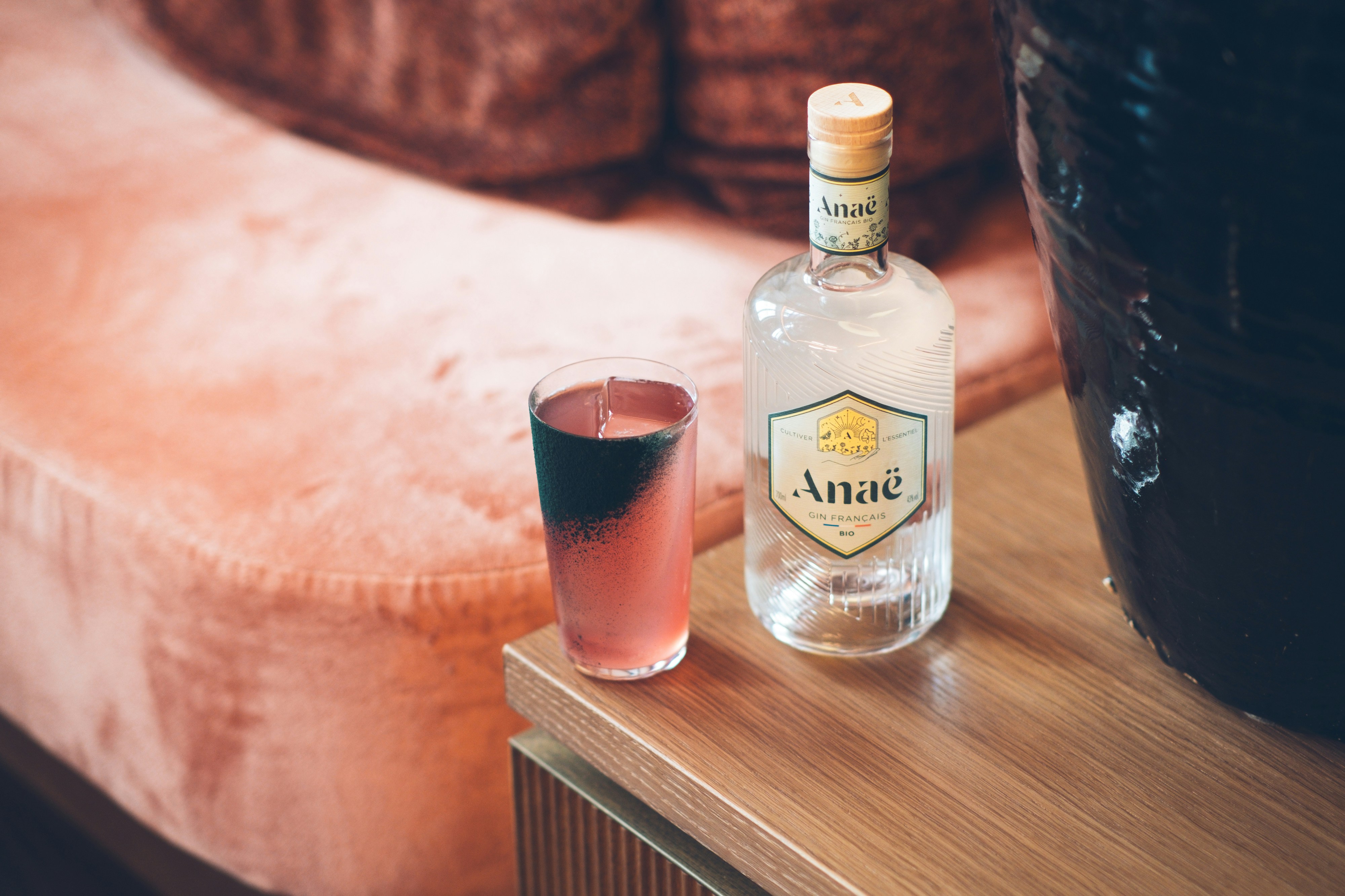 a bottle of alcohol sitting on a table next to a glass