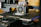 A close-up view of a 3D printer in action, focusing on the extruder head and the printed object forming on the print bed. The printer’s mechanical components and frame are visible, indicating its active status.