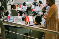 Teacher and children engaging with interactive learning games on tablets.