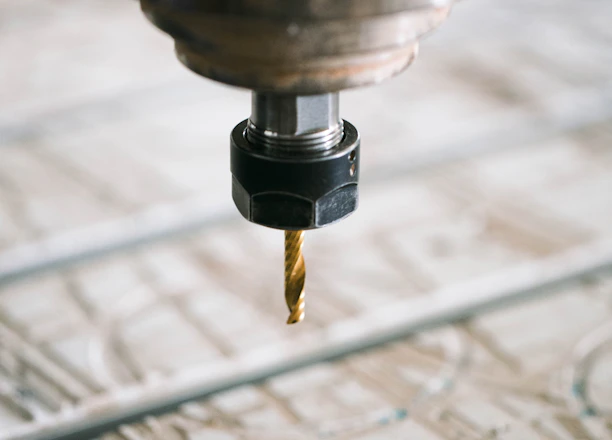 Close-up of a CNC milling machine precisely shaping a metal part in a workshop.