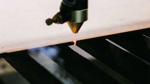 Close-up of a laser cutting machine precisely working on a sheet of stainless steel.