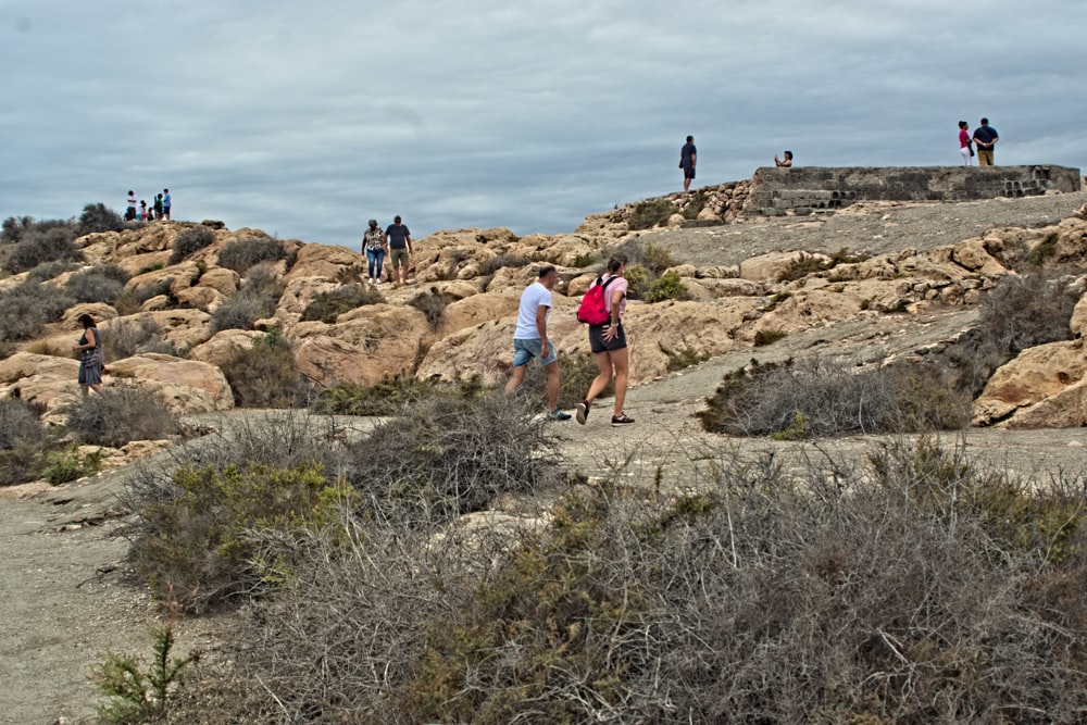 a group of people standing on top of a rocky hillside
