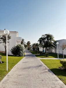 a brick walkway leading to a white building
